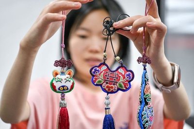 多彩贵州文化产业投资集团的工作人员在展示苗绣文创产品(5月23日摄)。新华社记者 杨文斌 摄
